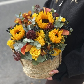 Композиция в сумке "Тональность" из подсолнухов, калл, ягод вибирнума, лимонных роз, скиммии и орхидеи в Реутове